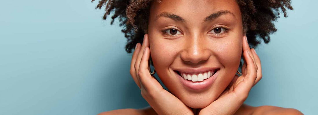 Lady with curly hair and smiling pleasantly | Retinol Skincare Product at Beauty Boost Med Spa in Newport Beach, CA