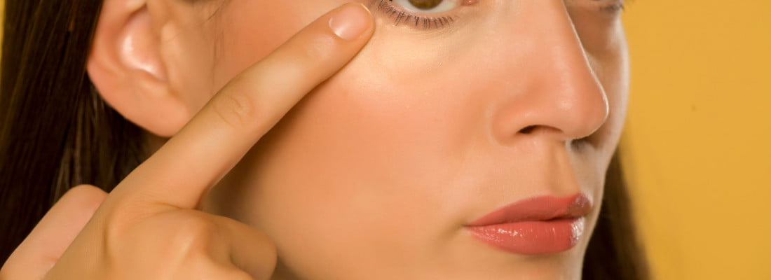 Pretty lady pointing finger near eyes | Get PRF under Eye treatment at Beauty Boost Med Spa in Newport Beach, CA